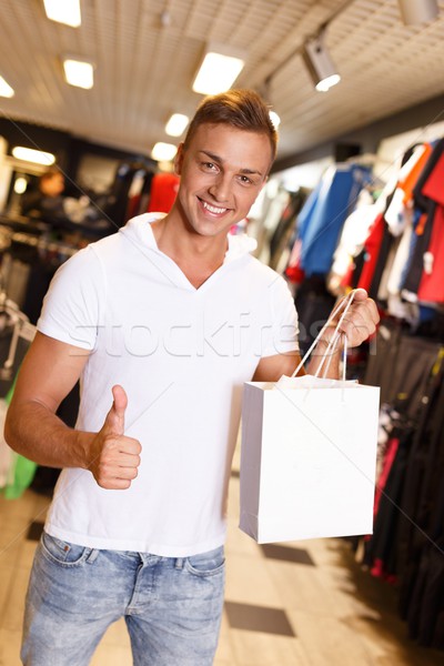 Happy handsome young with with shopping bag in sport outlet Stock photo © Nejron