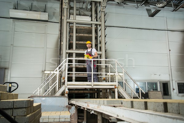 Man in a safety hat taking notes on a factory   Stock photo © Nejron
