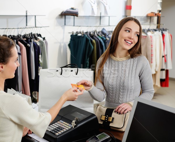 Happy woman customer paying with credit card in fashion showroom Stock photo © Nejron