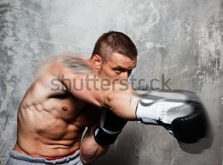 Young sporty man in boxing gloves in motion Stock photo © Nejron