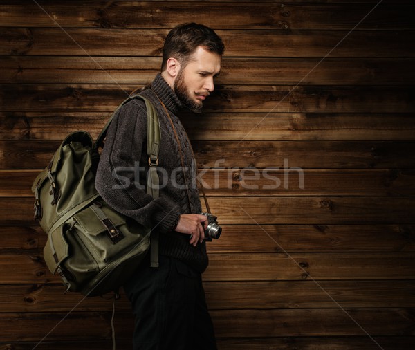 Handsome man wearing cardigan with backpack and vintage camera in house interior  Stock photo © Nejron