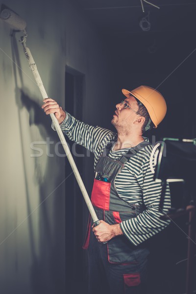 Builder applying paint on a wall with roll  Stock photo © Nejron