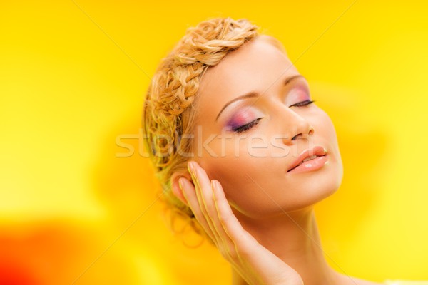Beautiful young woman with hairdo touching her face with hand Stock photo © Nejron