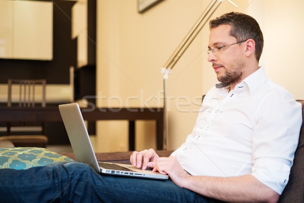 Jonge man grijs haar laptop sofa home interieur Stockfoto © Nejron