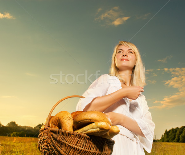 Beautiful young woman with a basket full of fresh baked bread Stock photo © Nejron