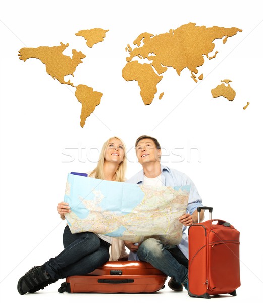 Smiling beautiful young couple with a map sitting on a suitcase Stock photo © Nejron
