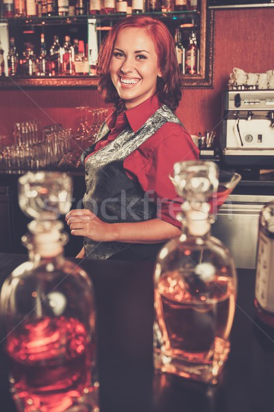 Beautiful redhead barmaid behind bar counter Stock photo © Nejron