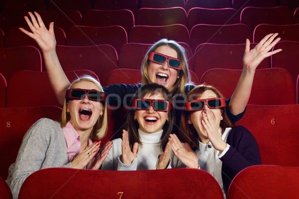 Group of excited young girls watching movie in cinema Stock photo © Nejron