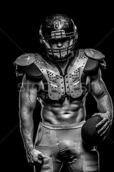 Stock photo: American football player with ball wearing helmet and protective shields 