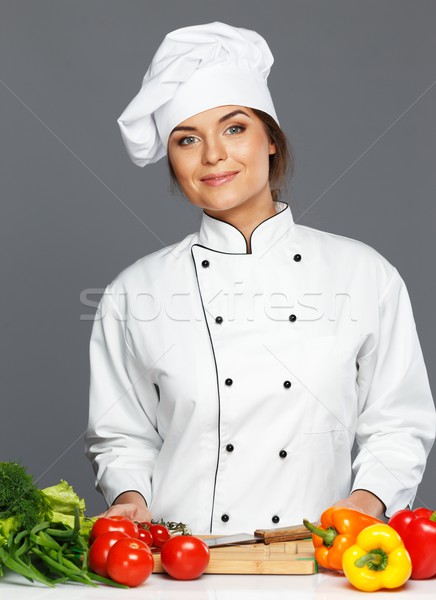 Beautiful young woman cook with fresh vegetables on cutting board  Stock photo © Nejron