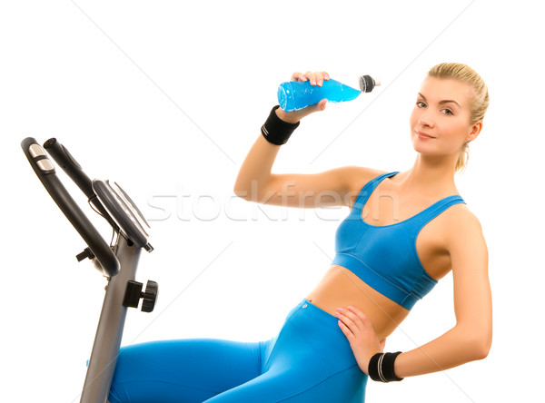 Beautiful young woman on exercise bicycle over white background Stock photo © Nejron