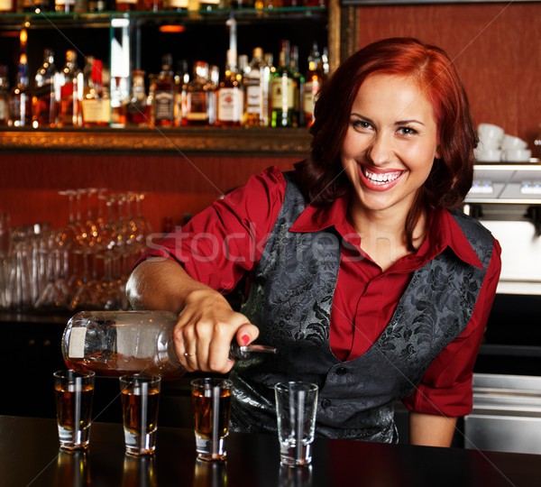Beautiful redhead barmaid making shots Stock photo © Nejron