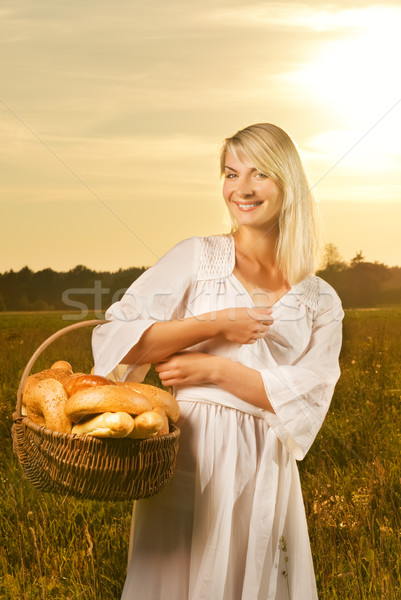 Beautiful young woman with a basket full of fresh baked bread Stock photo © Nejron