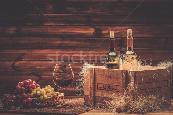 Bottles of red and white wine, glass and grape on a wooden interior  Stock photo © Nejron