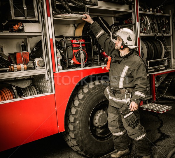 Fireman taking equipment from firefighting truck  Stock photo © Nejron