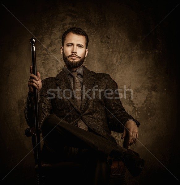 Handsome well-dressed man with walking stick sitting in leather chair  Stock photo © Nejron