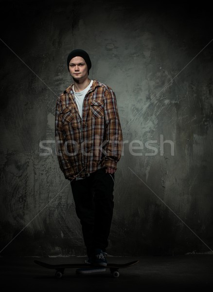 Young man in hat and shirt standing on his skateboard Stock photo © Nejron