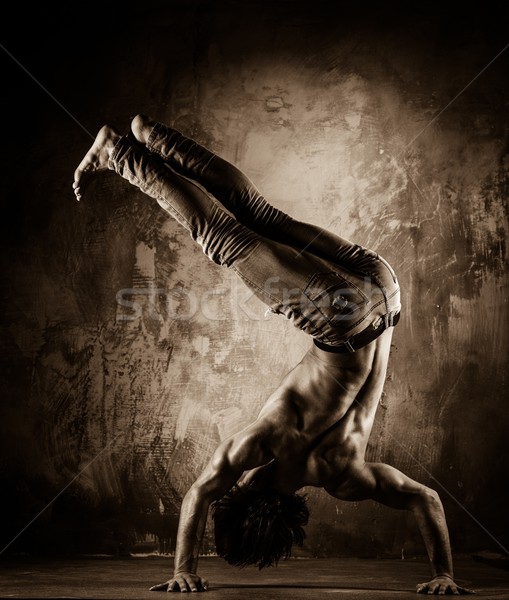 Toned picture of young man with naked torso doing acrobatic movements  Stock photo © Nejron
