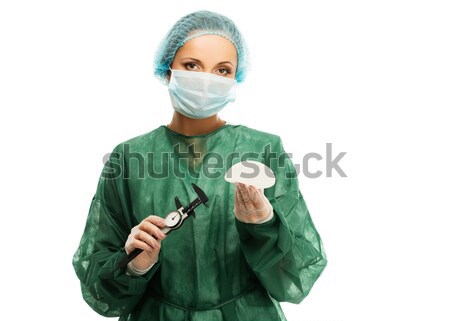 Plastic surgeon woman in cap and mask holding silicon breast implants  Stock photo © Nejron