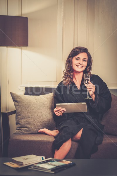 Woman in bathrobe relaxing with glass of champagne and  tablet pc Stock photo © Nejron