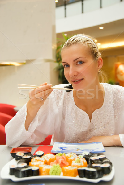 Beautiful girl eats sushi in a restaurant Stock photo © Nejron