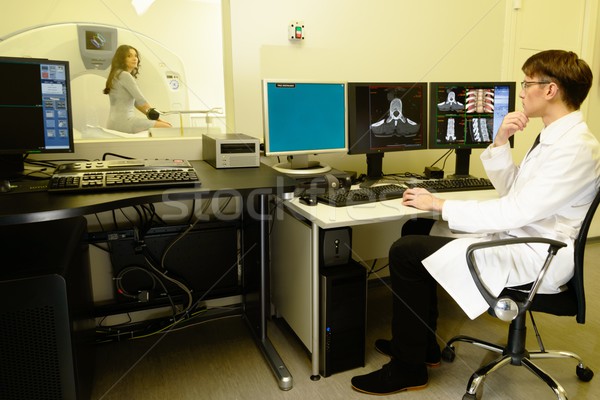 Young doctor sitting behind monitors in a computed tomography laboratory  Stock photo © Nejron