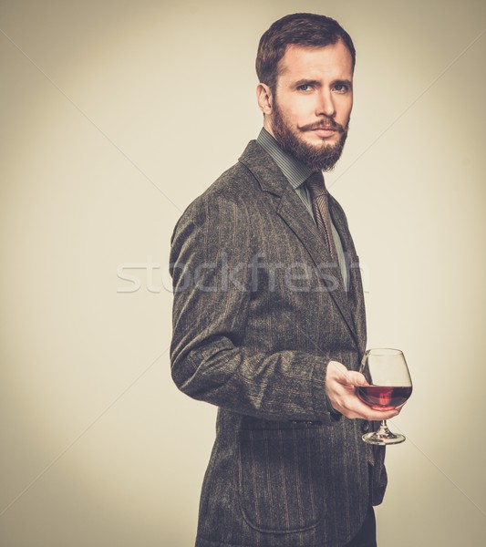 Handsome well-dressed man in jacket with glass of beverage Stock photo © Nejron