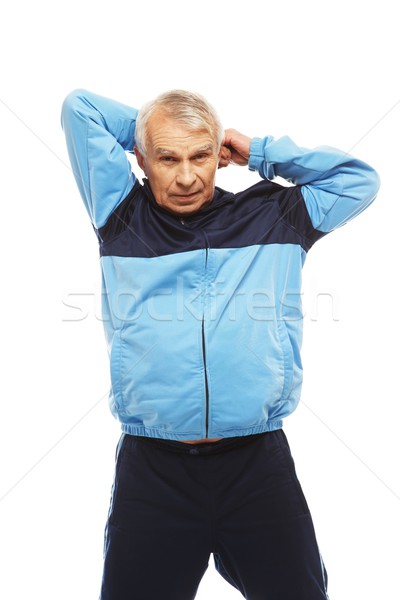 Senior man in training suit doing warm-up stretching exercises  Stock photo © Nejron