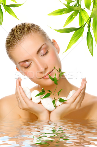 Beautiful woman holding young plant growing up through stones re Stock photo © Nejron