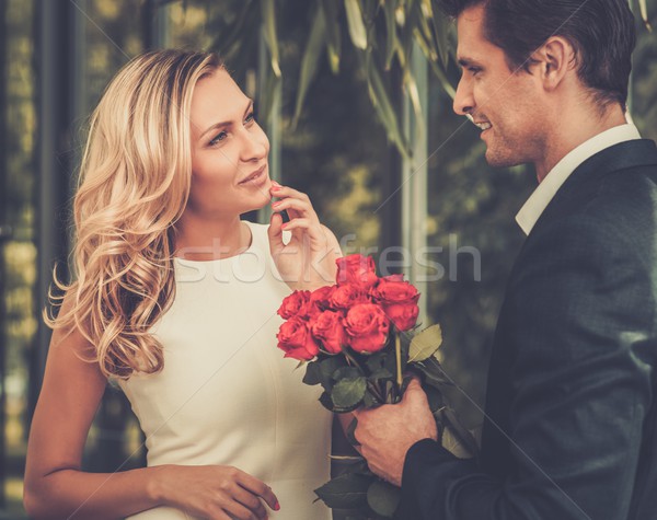 Handsome man with bunch of red roses dating his lady Stock photo © Nejron