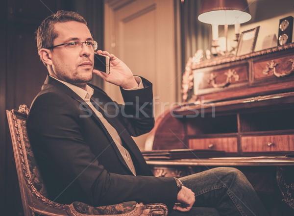 Confident middle-aged man with mobile phone in luxury interior  Stock photo © Nejron