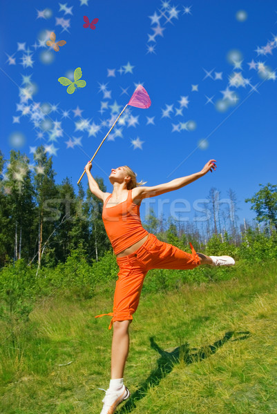 Stock photo: Beautiful girl with a net in her hand trying to catch magic butt