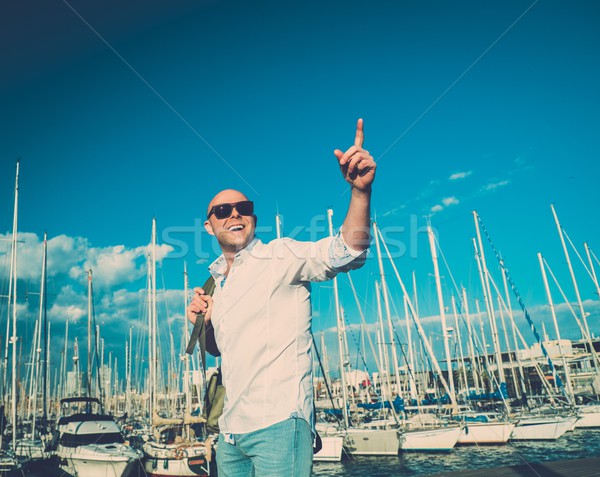 Happy middle-aged man with backpack against yacht port Stock photo © Nejron