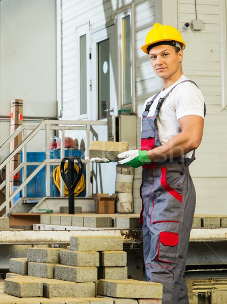 Young worker near conveyor belt with paving stone  on a factory   Stock photo © Nejron