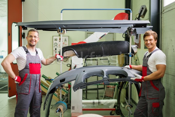 Two workers with car bodykit ready for painting in a workshop Stock photo © Nejron