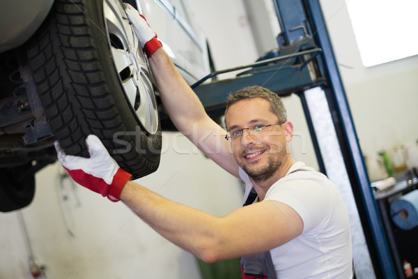 Mechanic checking wheel bearings in a car workshop  Stock photo © Nejron