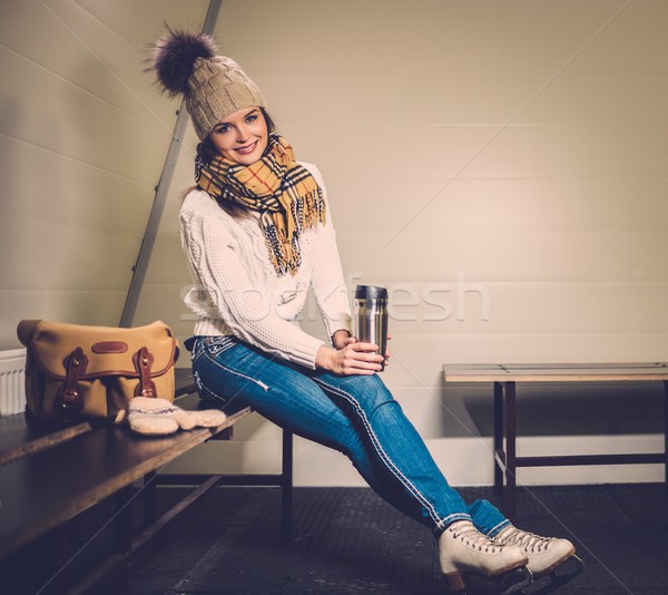 Cheerful girl with mug of hot drink in ice rink locker room  Stock photo © Nejron