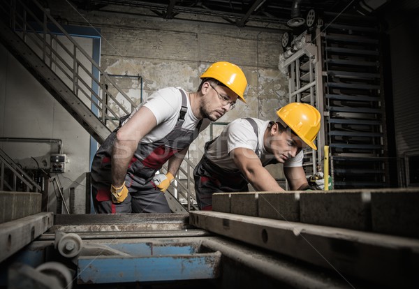 Worker and foreman in a safety hats performing quality check on a factory   Stock photo © Nejron