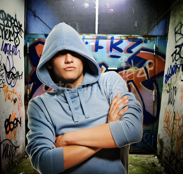 Stock photo: Cool looking hooligan in a graffiti painted gateway