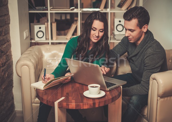 Young couple with laptop and coffee behind table Stock photo © Nejron