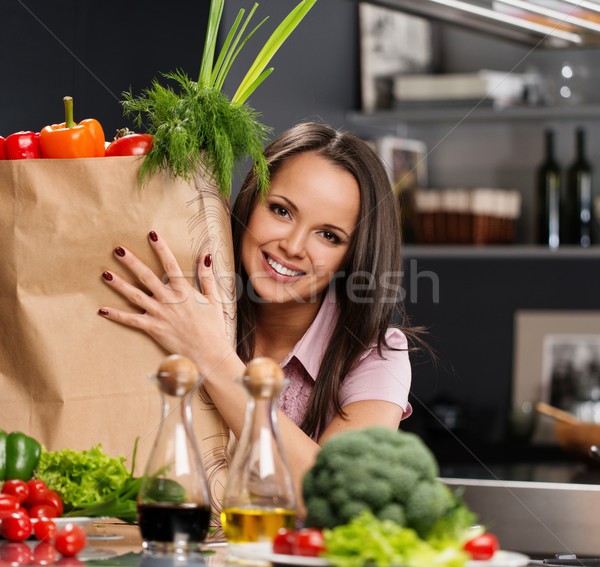 Young woman with grocery bag full of fresh vegetables on a modern kitchen Stock photo © Nejron