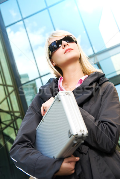 Beautiful young woman with silver case near the modern office bu Stock photo © Nejron