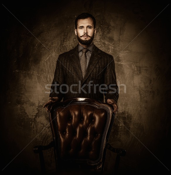 Handsome well-dressed  standing near leather chair  Stock photo © Nejron