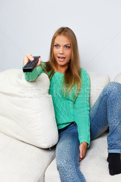 Young beautiful woman on a sofa with remote control  Stock photo © Nejron