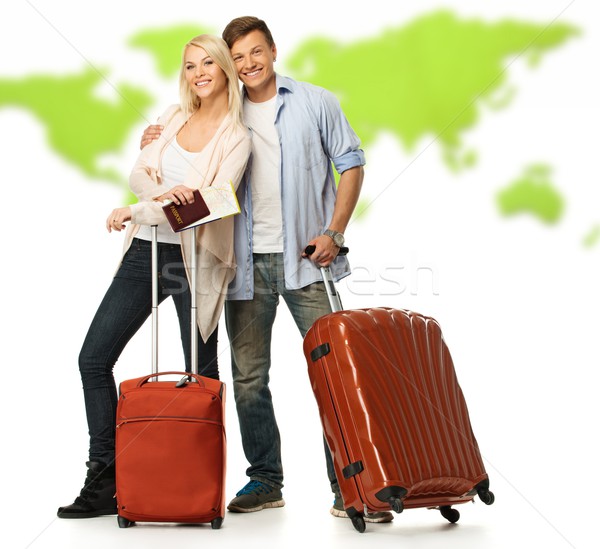 Stock photo: Happy couple with suitcases and documents against world map