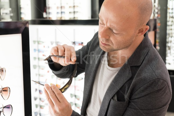 Middle-aged man choosing sunglasses in a shop Stock photo © Nejron