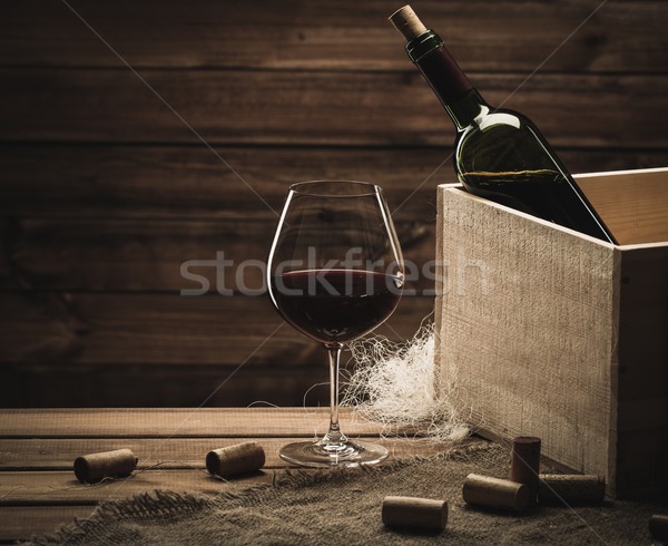 Bottle and glass of red wine on a wooden table  Stock photo © Nejron