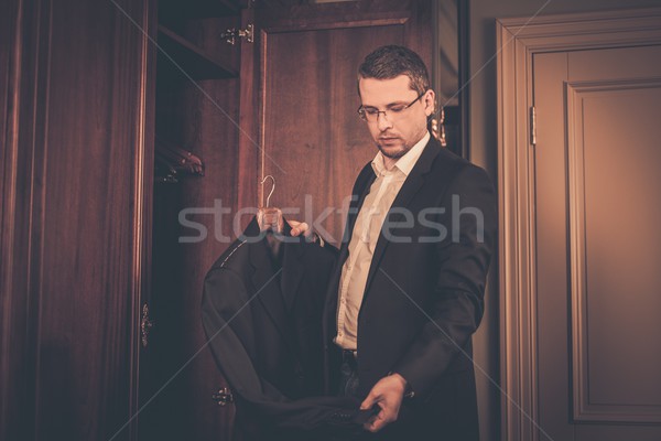 Middle-aged man taking suit from wardrobe  Stock photo © Nejron