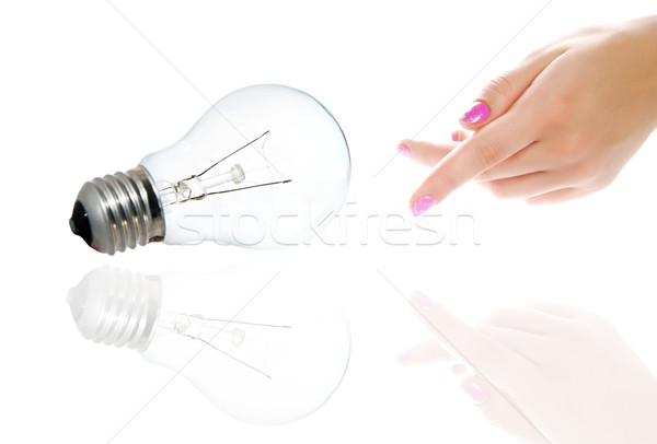 Beautiful woman's hand pointing to tungsten bulb. Isolated on wh Stock photo © Nejron