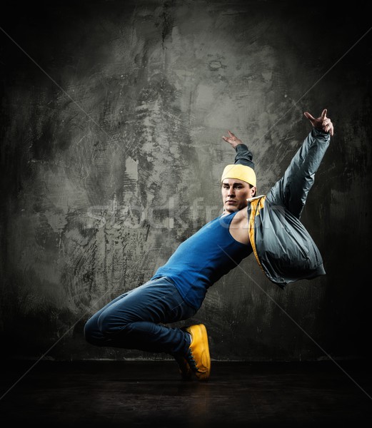 Man dancer in cap and jacket showing break-dancing moves Stock photo © Nejron